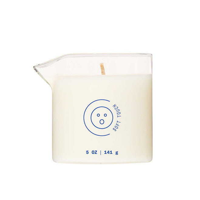 The Soft Touch Massage Oil Candle by Dame (Benzoin, Guaiac Wood & Sandalwood) is a 5 oz plant-based candle in clear glass with a spout, designed to moisturize skin and soothe senses with a gentle touch.