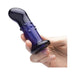 A hand holds the Glas Rechargeable Remote-Controlled G-Spot & Prostate Vibrator, a dark blue glass plug with a flared base and raised bumps. Its smooth, glossy finish and beginner-friendly design ensure inviting comfort during use.