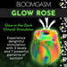 The Bloomgasm Glow Rose Glow-in-the-Dark Clitoral Stimulator uses air pulse tech with 3 intensities and 7 suction patterns for clitoral pleasure. Shown on a vibrant floral background with the product name displayed.