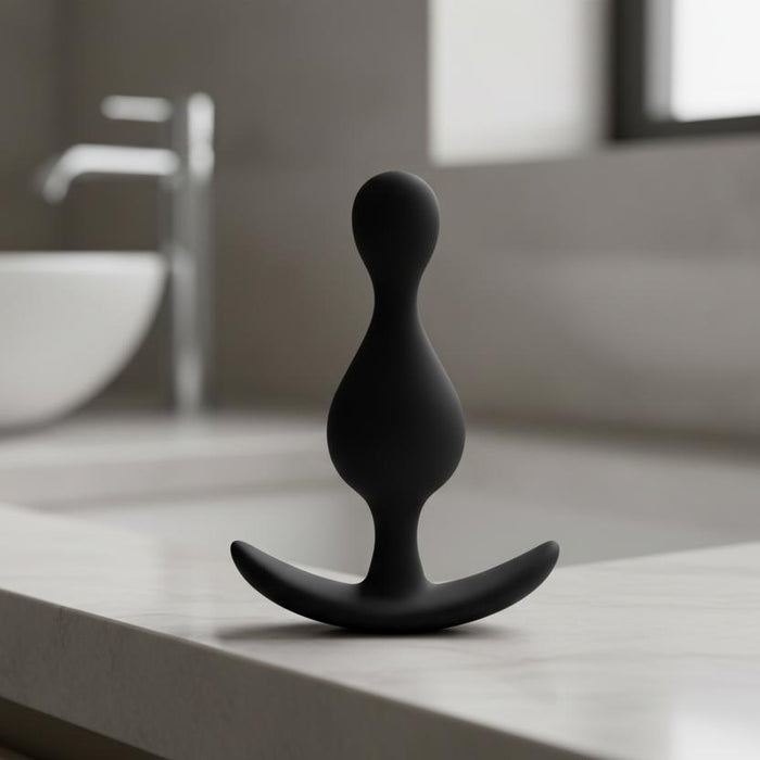 The Anal Adventures Wave Butt Plug, made from black platinum silicone with a curved base, is displayed on a plain white background—ideal for anal exploration.