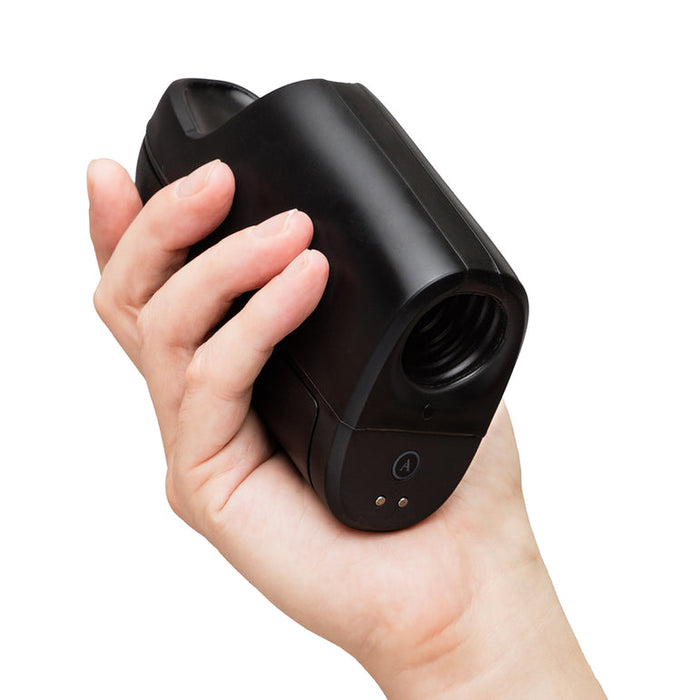 A hand holds the Arcwave Ion 2 Penis Masturbator with Pleasure Air Suction, a sleek black silicone stroker featuring an opening at one end and small indicator lights near the base, set against a white background.