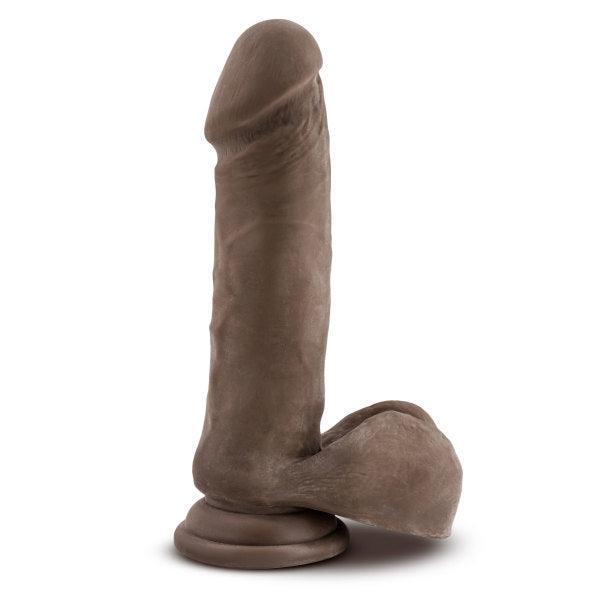 The Au Naturel Long 8 Inch Dual Density Dark Tone Suction Cup Dildo with Balls, featuring lifelike texture and a pronounced head, stands upright against a plain white background.