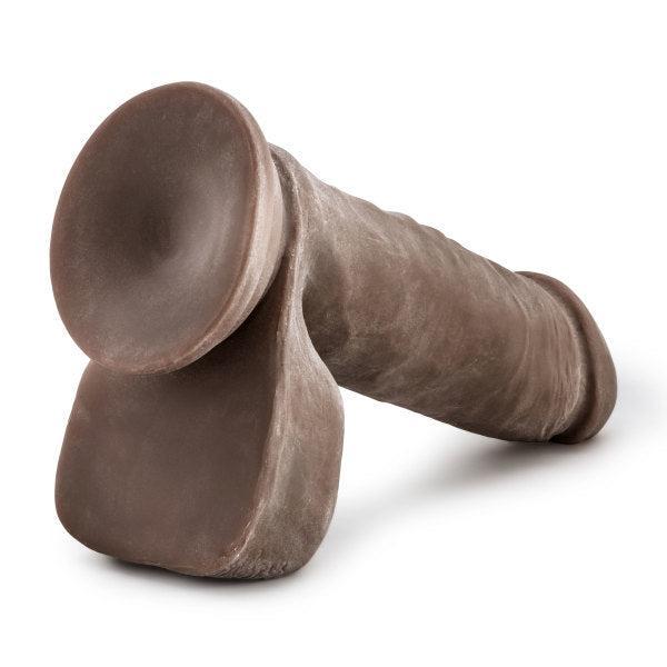 The Au Naturel Long 8 Inch Dual Density Dark Tone Suction Cup Dildo with Balls, chocolate-colored and realistically shaped, is displayed on a white background.