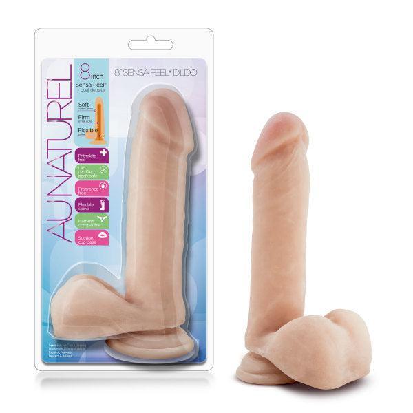 The Au Naturel Long 8 Inch Dual Density Light Tone Dildo with Balls is shown in flesh tone with a sturdy suction cup base, displayed next to its clear packaging featuring product details and the "Au Naturel" brand.