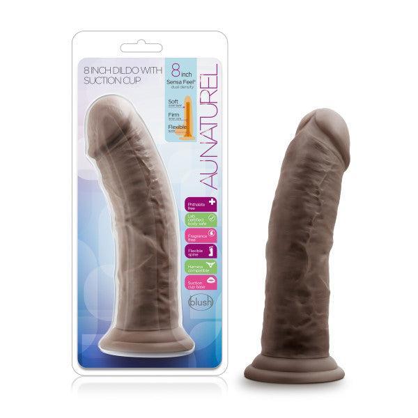 The Au Naturel Thick 8 Inch Realistic Feel Dual Density Dark Tone Suction Cup Dildo is displayed beside its packaging, showcasing its harness compatibility and soft yet firm, flexible material.