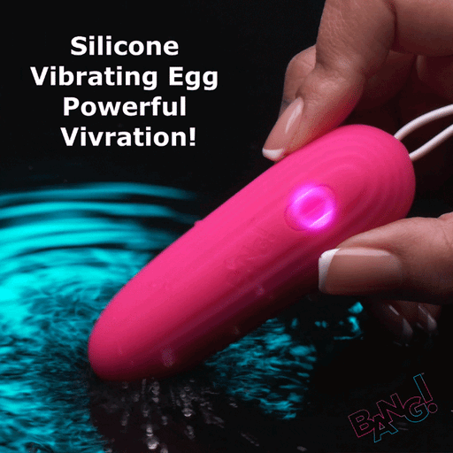 A hand holds the Bang Waterproof Silicone Vibrating Egg, glowing bright pink above rippling blue water. Bold text states, "9 Vibration Functions! Powerful Stimulation." The Bang logo is in the corner.