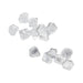 Small, clear crystals from the Beloved Vacation Lovin' Intimacy Kit are scattered on a white background, evoking the allure of sensual travel essentials.