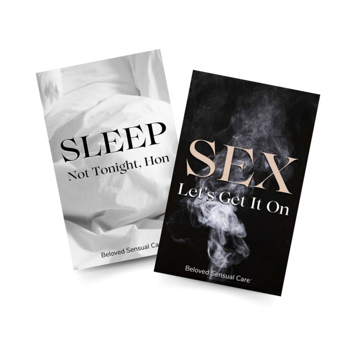 Two cards: one with rumpled sheets reading "SLEEP Not Tonight, Hon," the other with smoke and "SEX Let's Get It On." Both feature the Beloved Vacation Lovin' Intimacy Kit—your must-have for unforgettable travel nights.