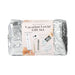 A silver quilted pouch features a label for the Beloved Vacation Lovin' Intimacy Kit, showing sensual travel essentials inside like skincare items, cleansing cloths, a mood card, and a toy.