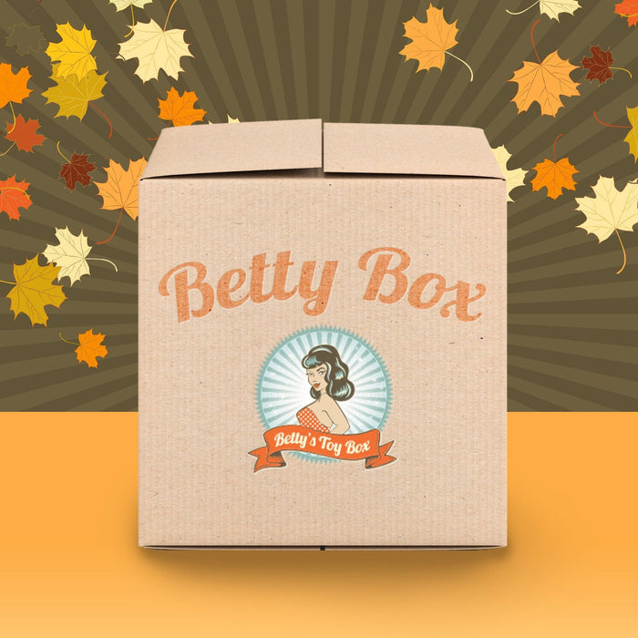 Unbox excitement with the "Betty's Treats for Two Couples Mystery Box - Fall Edition," featuring a retro-inspired design and autumn leaves—perfect for discovering sexy games and couple toys together.
