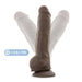 The Big Boy Huge 10 Inch Dual Density Dark Tone Suction Cup Dildo stands upright, showcasing its flexible spine feature with two bent positions and a "Flexible Spine" label. It's strap-on compatible for versatile use.