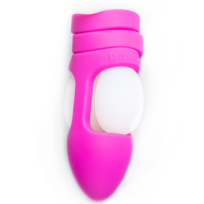 The Balldo: The World's First Ball Dildo features a pink ergonomic silicone sleeve wrapped around two white ovals, designed for testicle penetration, shown on a white background.