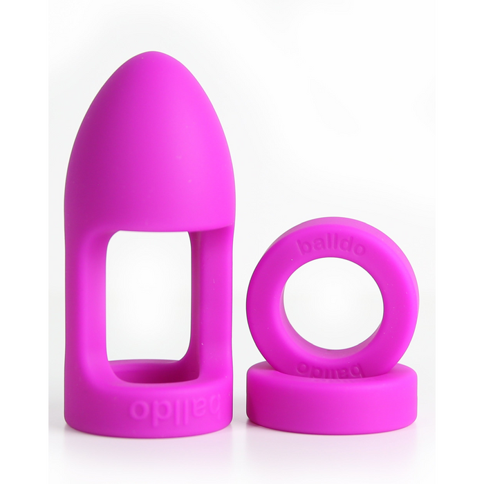 Two bright pink silicone "balldo"-labeled rings—one rounded with a rectangular window, one circular—designed for testicle penetration and ballgasm pleasure, are displayed upright as Balldo: The World's First Ball Dildo on a white background.