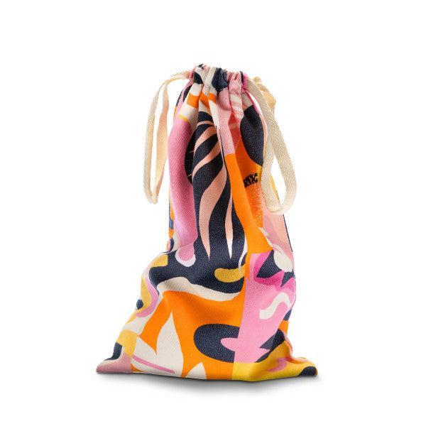 The Blush Burst Colorful Toy Storage Bag from Blush is shown with a vibrant abstract pattern in pink, orange, white, black, and yellow. This cotton bag cinches at the top with beige drawstrings and is machine washable.