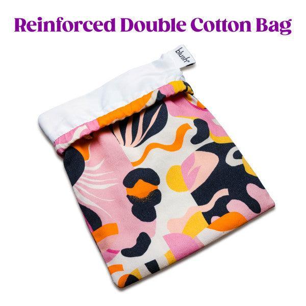 The Blush Burst Colorful Toy Storage Bag by Blush is a vibrant cotton storage solution with a reinforced double layer. It features an abstract pattern in shades of pink, orange, yellow, black, and white, and is partly closed with a white drawstring top. Machine washable and perfect for sex toy storage, it has the text "Reinforced Double Cotton Bag" displayed above the bag.