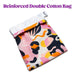 The Blush Burst Colorful Toy Storage Bag by Blush is a vibrant cotton storage solution with a reinforced double layer. It features an abstract pattern in shades of pink, orange, yellow, black, and white, and is partly closed with a white drawstring top. Machine washable and perfect for sex toy storage, it has the text "Reinforced Double Cotton Bag" displayed above the bag.