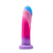 The Borealis Dreams Girthy Textured 7.75 Inch Silicone Dildo features a swirled blue, pink, and purple design, stands upright on a flat base, and is harness compatible, shown against a white background.