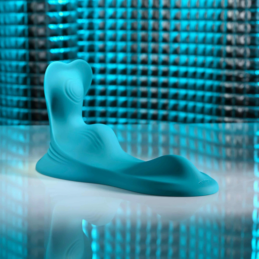 The Bumps & Grind Triple Bump Flexible Grinding Vibrator, an abstract blue silicone sensory pad, rests on a reflective surface with a textured metallic blue background.