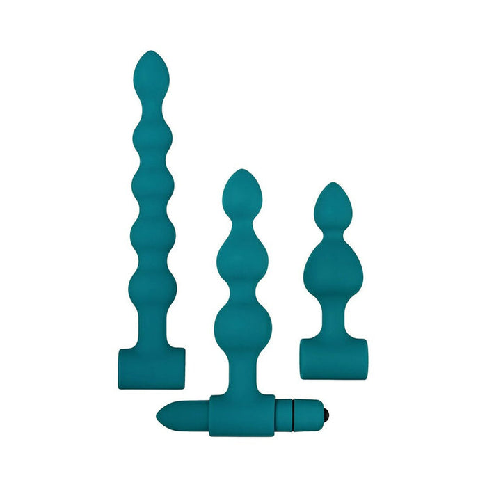 The Bumpy 3-Piece Beaded Anal Plug Set with Vibrating Bullet features three teal, wavy silicone plugs in graduated sizes, each with a flared base. One plug includes a removable vibrating bullet. Shown on a plain white background.