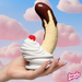 A hand with long, glittery nails holds the Chocolate Dipped Banana Split Silicone Dildo with Suction Cup, standing upright in whipped cream and a cherry, set against a pink cloud sky. The Simply Sweet logo appears in the corner.