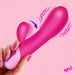 A hand with pink-painted nails holds the Clit Tapping Rabbit Flexible Silicone Vibrator against a pink background, with vibration lines and an arrow showing G-spot stimulation. "BANG!" pops in the corner for extra excitement.