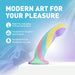 The Daydream Smooth Slim Silicone Dildo with Suction Cup, in pastel rainbow hues, sits on a white platform. Its body-safe silicone and elegant design promise comfort, satisfaction, and visual appeal against a dreamy backdrop.