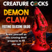 A red and black silicone sex toy shaped like a demon’s claw stands upright against a fiery volcanic backdrop. Bold text announces the "Demon Claw Long Thick Fantasy Fisting Silicone Dildo" by Creature Cocks.