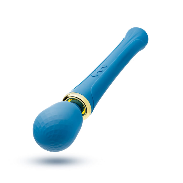 Image shows the Dianna Rechargeable Rumbly Waterproof Wand Vibrator by Blush, a blue handheld personal massager with a textured, rounded head and a smooth handle. A gold ring separates the head from the handle, which features subtle line designs. This luxurious wand offers 20 vibrating patterns and is waterproof, positioned against a plain white background.