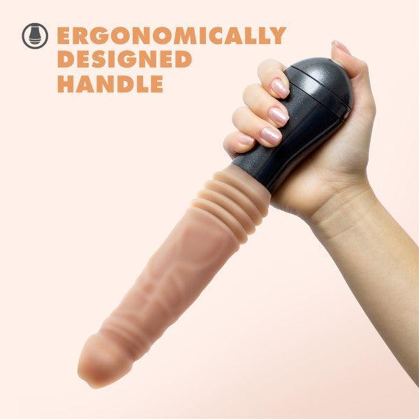 A hand holds the Blush Dr. Knight Vibrating Thrusting Gyrating Realistic Silicone Dildo in Vanilla, featuring an ergonomic black handle. The text "ERGONOMICALLY DESIGNED HANDLE" is displayed in capital letters on the left side of the image.
