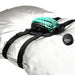 A gray pillow with black straps holds the turquoise and black Dragon Grinder - Vibrating Silicone Fantasy Pad, featuring dragon scale designs. Includes a small "Creature Couch" remote. This waterproof, rechargeable pad brings fantasy to life.