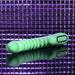 The Full Throttle Warming Waterproof Silicone Vibrator, featuring a ribbed green shaft and control buttons, rests on a reflective surface against a purple textured background.