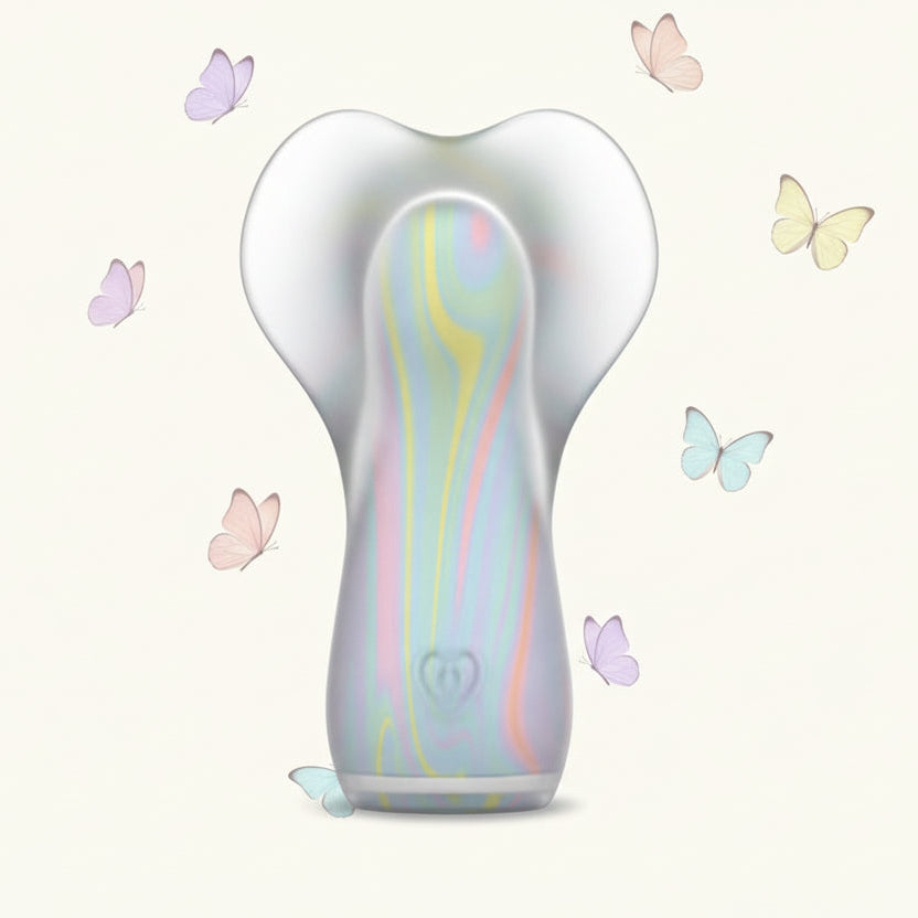 The Fancy Flutter Squishy Waterproof Silicone Vibrator, featuring a pastel design and ergonomic, translucent butterfly top, is centered on a light background with softly colored butterflies fluttering around it.