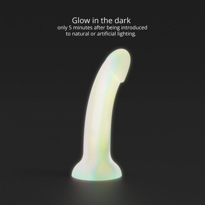 The Fantasia Smooth 7 inch Glow in the Dark Silicone Dildo with Suction Cup stands upright on a dark background, text above reads: “Glows after 5 minutes of light exposure—ideal for pegging and fun nighttime play.”.