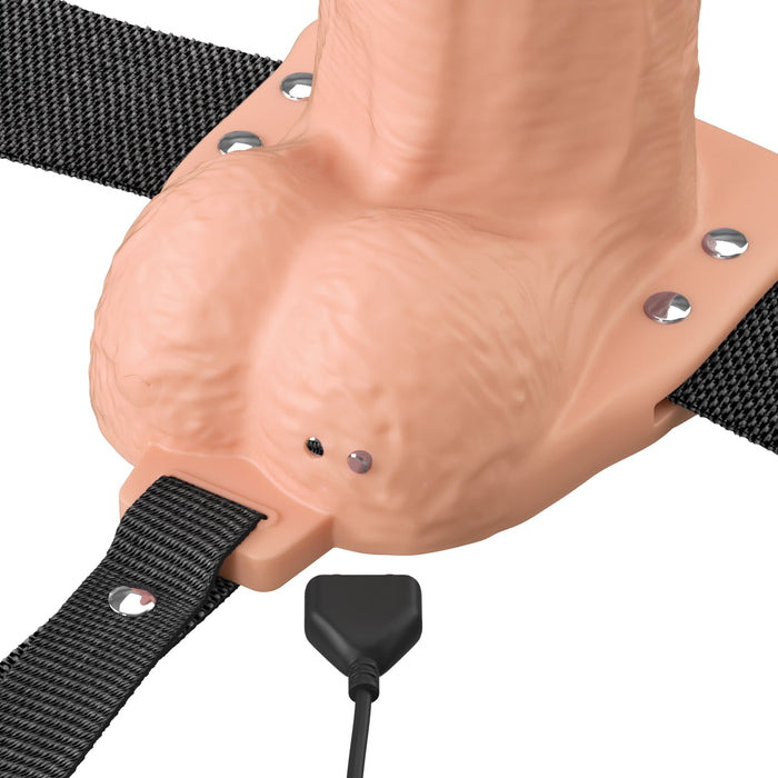 The Fantasy X-Tensions Elite Vibrating Hollow 7 Inch Silicone Dildo & Strap-On Harness - Vanilla, featuring a realistic vanilla tone, black straps, and a corded control, is displayed against a white background.