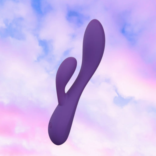 The Fever Dream Beginner G-Spot Rabbit Vibrator, a purple dual-ended toy, floats against a pastel sky with pink and blue clouds—ideal for those new to G-spot stimulation.