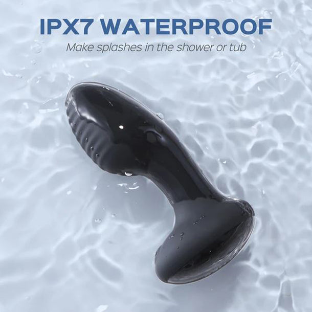 A black Frenzy Pressure Sensing App-Controlled Butt Plug rests in a shallow pool of water. Text above reads "IPX7 WATERPROOF – Make splashes in the shower or tub.