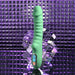 The Full Throttle Warming Waterproof Silicone Vibrator, in green with a ribbed shaft and control buttons, is shown upright on a reflective geometric surface against a purple textured background.