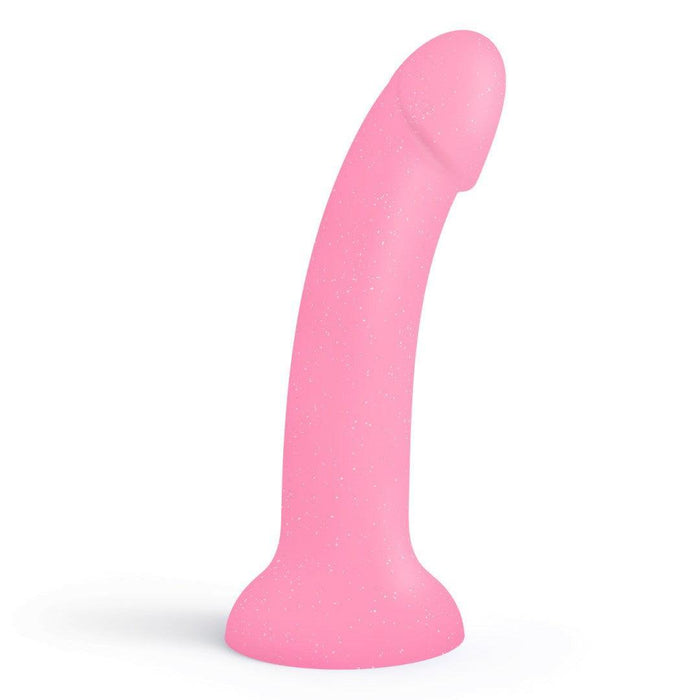The Glitzy Smooth 7 inch Pink Sparkle Silicone Dildo with Suction Cup, featuring a curved, realistic shape and flared base, stands upright against a white background.