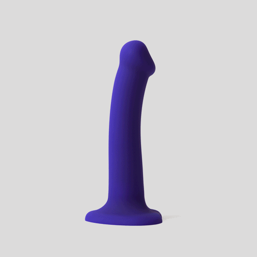 The Glow Light Up Blue LED 7 Inch Silicone Dildo, featuring a curved shaft and flared base that is strap-on harness compatible, stands upright against a plain light gray background.