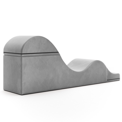 The Liberator Aria Flip Chaise Sex Lounger is a gray, modern, convertible bench with a wave-like design and smooth surface, discreetly blending into the bedroom against a plain white background.