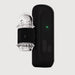 The Handy 2 Interactive Automatic Masturbator, a sleek black app-controlled device with a green indicator light, sits next to its clear textured silicone sleeve and adjustable black strap against a plain light background.