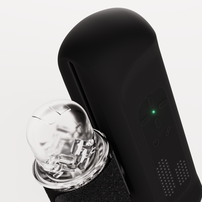 Close-up of The Handy 2 Interactive Automatic Masturbator, featuring a green indicator light and a transparent, rounded attachment that reveals internal components, set against a white background.