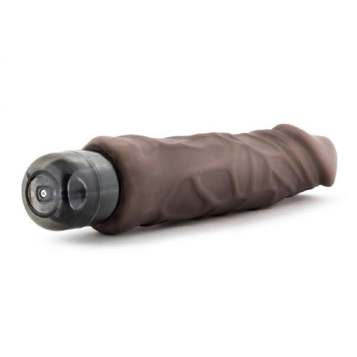 The Home Wrecker 9.5 Inch Vibrating Dildo in Chocolate features a realistic, textured surface with a black base and is shown lying on a white background.