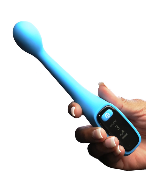 A person holding a Bang! First Time G-Spot Vibrator with Digital Display - Blue by XR Brands, shaped like a wand with a rounded head made of silicone. The USB rechargeable device has a display screen showing "MODE 3" and a button for power and mode controls. The person has long nails and is gripping the Bang! First Time G-Spot Vibrator handle firmly. The background is white.