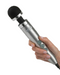 A person holding a Doxy Die Cast 3 Extra Powerful Wand Vibrator - Brushed Aluminum, a compact body microphone with a body-safe silicone head, ready to speak or perform.