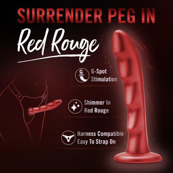 The Jealousy 7 Inch Rippled Red Silicone Dildo stands upright against a dark background, with text highlighting G-spot stimulation, red rouge shimmer, strap-on compatibility, and the phrase “Surrender Peg in Red Rouge.”.