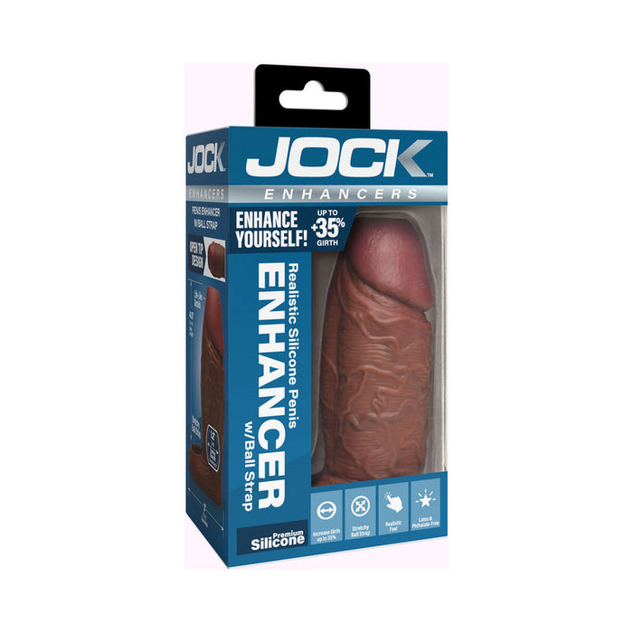 The Jock Girthy Open Ended Silicone Penis Sleeve - Chocolate is a realistic, chocolate-colored enhancer with an open-ended tip and stretchy ball strap, packaged in a blue and white box featuring promotional images and text.