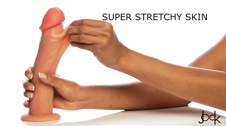 A hand stretches the outer skin of the Jock Real Skin Thick 8 Inch Light Tone Silicone Suction Cup Dildo, showing its flexibility. Text on image: "SUPER STRETCHY SKIN." The brand logo appears in the bottom right corner.