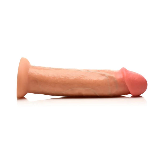 The Jock Real Skin Thick 8.5 Inch Light Tone Silicone Suction Cup Dildo, featuring a lifelike flesh tone and pink tip, is displayed lying on its side against a white background.