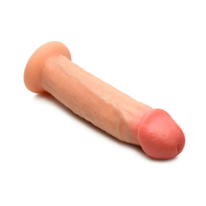 The Jock Real Skin 8.5 Inch Silicone Suction Cup Dildo - Vanilla by XR Brands, showcased against a white background, boasts a beige shaft with a pink tip and is compatible with strap-on harnesses for versatile use.